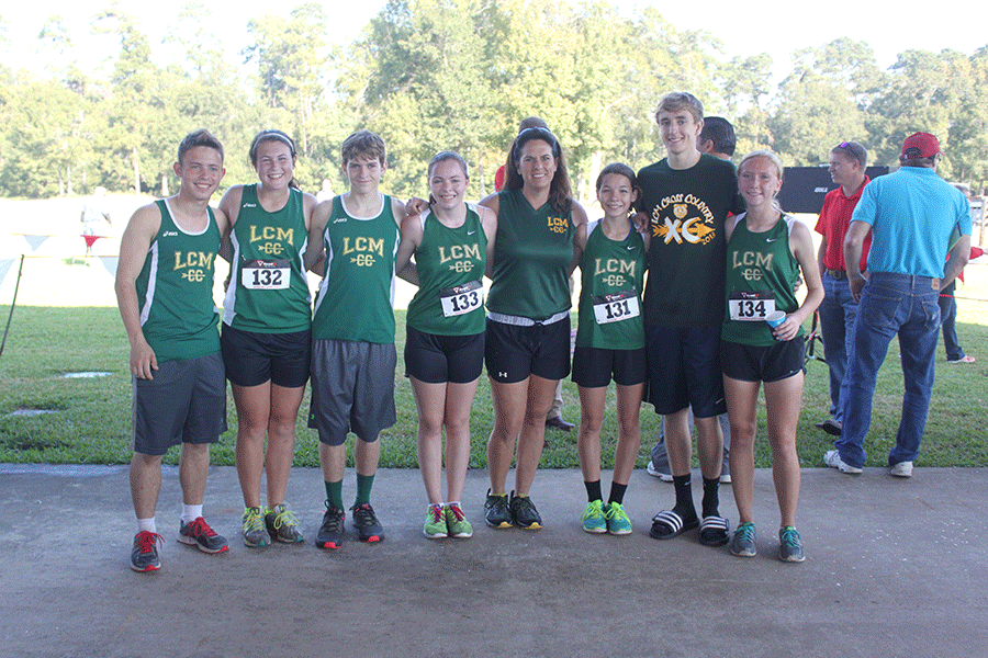 The cross country team and coach Dena Adkins celebrate big victories after the district race. 