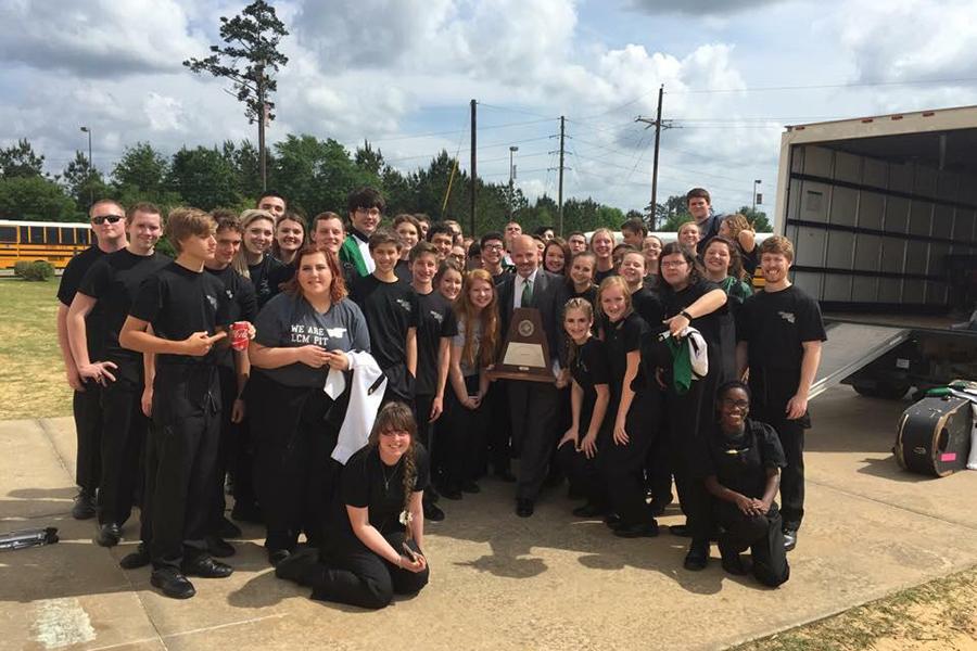 The Wind Ensemble proudly shows off its Sweepstakes trophy with Band Director Steve Schoppert. 