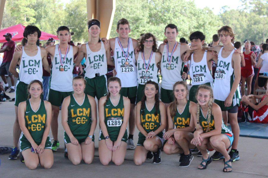 The cross country team shows off their medals after the District meet. 