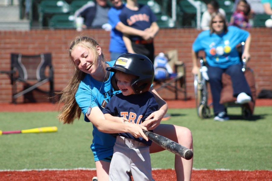 Junior Emily Landry helps Kyler Thayer swing the bat.