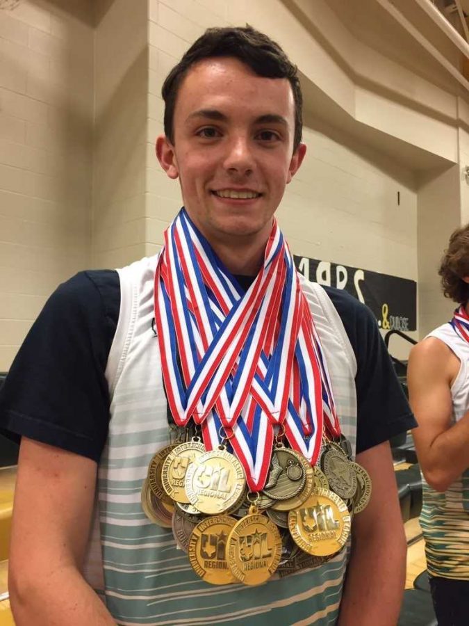 Senior Eli Peveto shows off his many medals from years of winning cross country meets. 