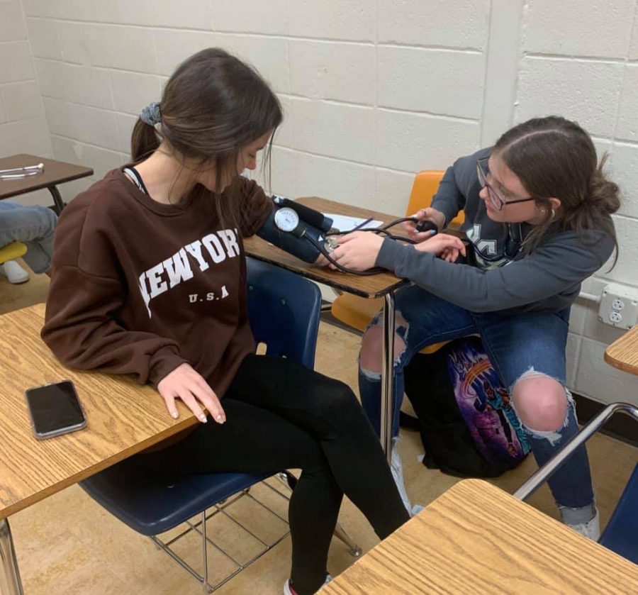 Students in Principles of Health Science practice checking each others blood pressure. 
