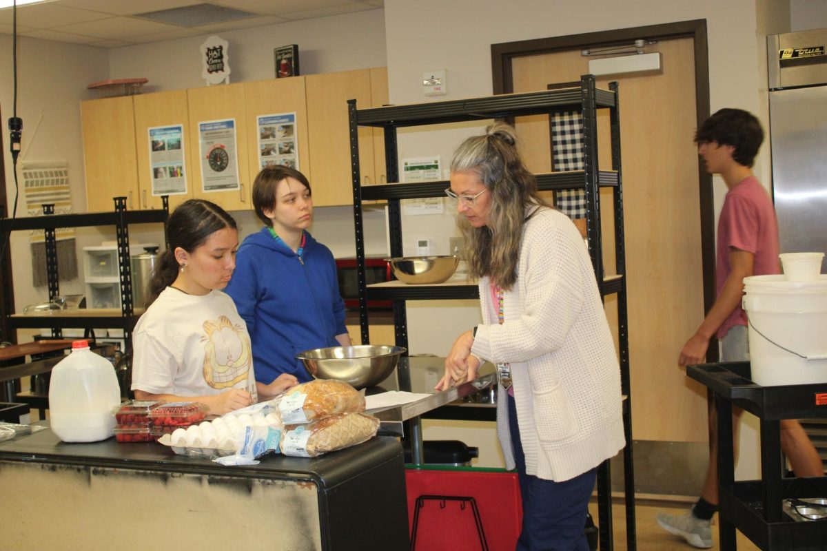 Culinary teacher Rochelle Briggs works with her students in the kitchen. 