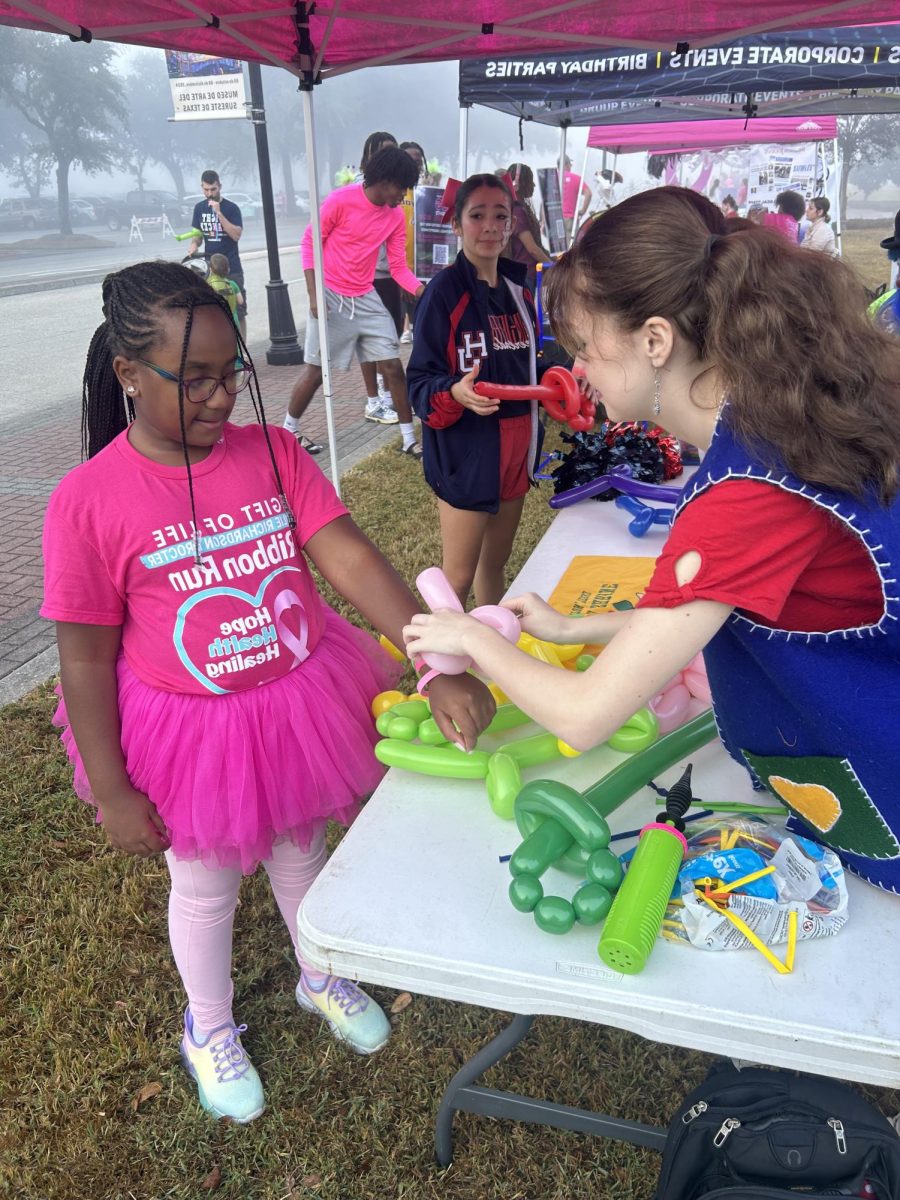 Laura Hughes tying balloons at the Walk for Cancer in October 2024