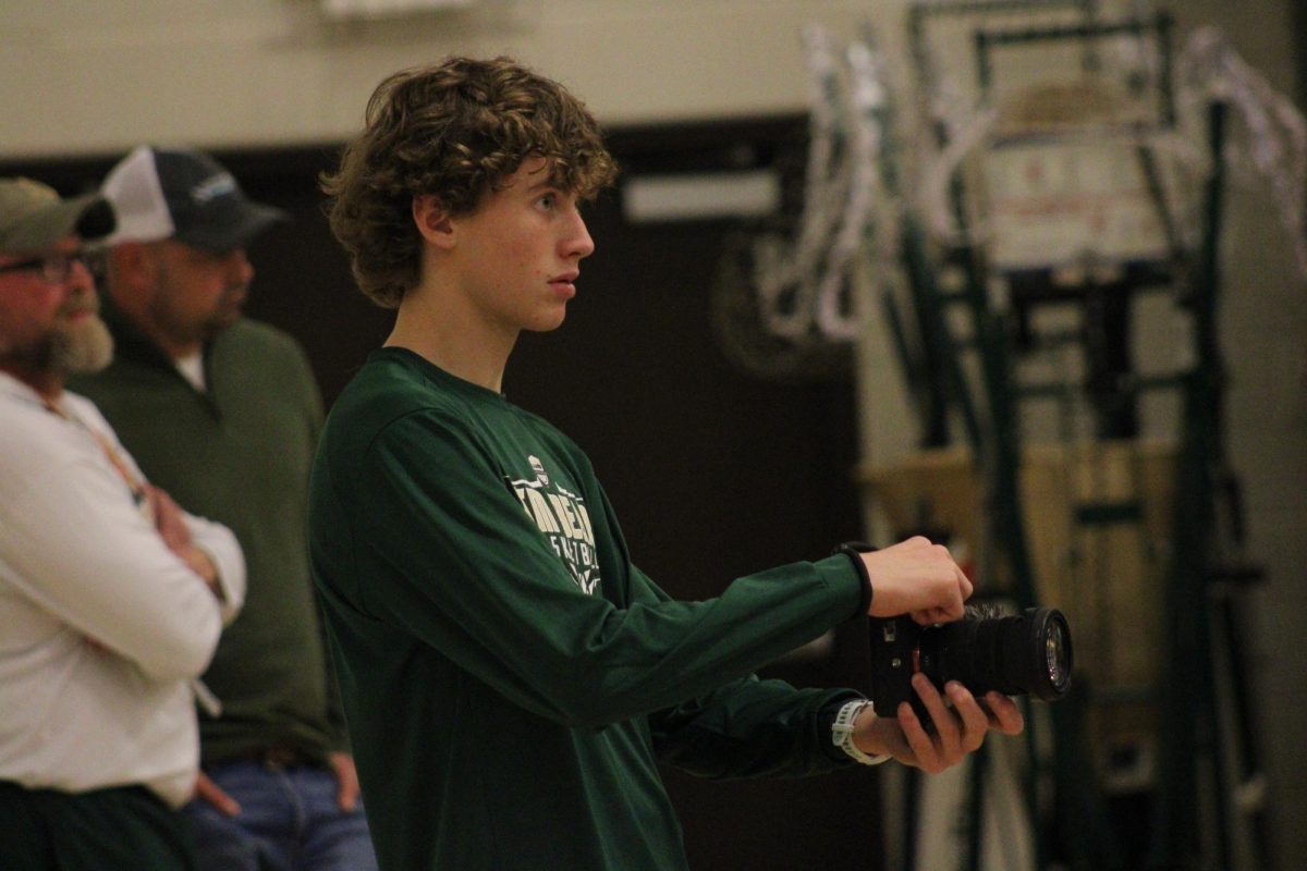Junior Chase Peacock gets video footage at a varsity boys basketball game. 