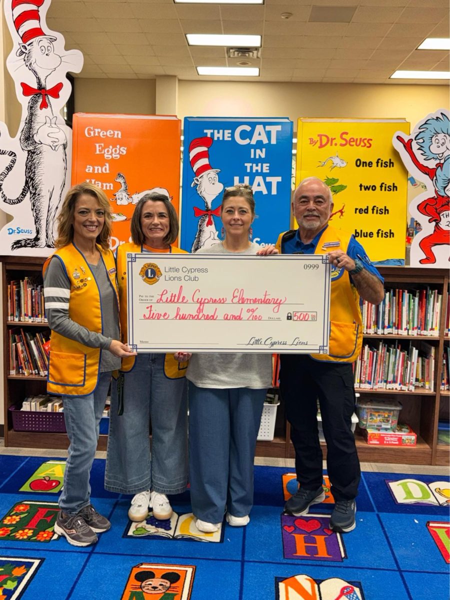 The LCE library receives a $500 donation for the Scholastic Book Fair.
