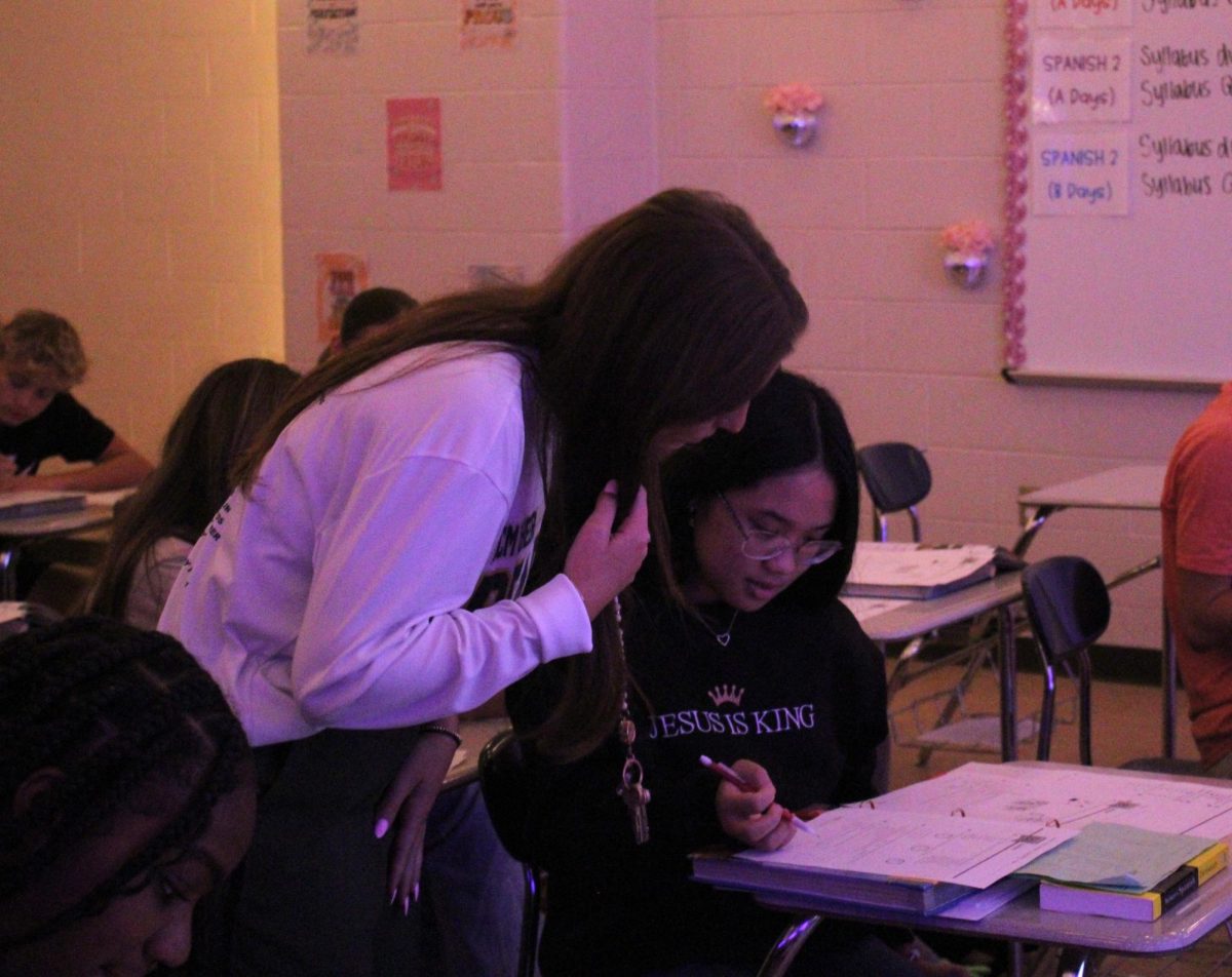 Spanish one and two teacher Jordyn Knighton helps a student with classwork.
