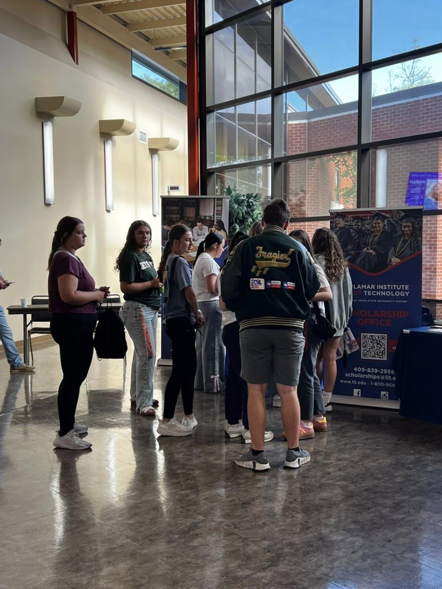 Students listening to presentation at a booth.